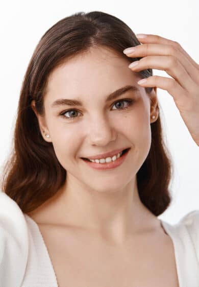 attractive young woman holding camera stretched hand taking selfie making her photo mobile phone smiling standing white background
